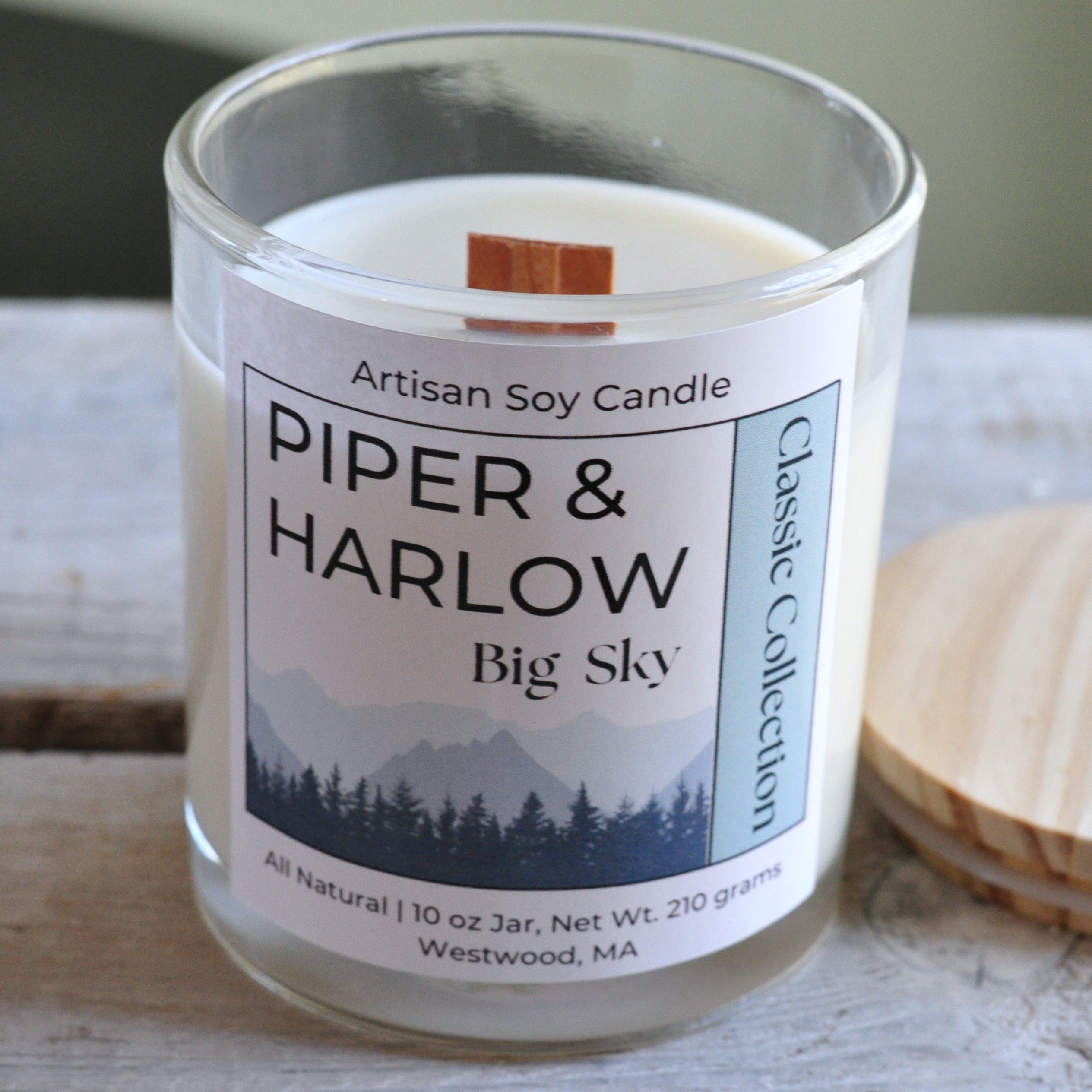 Big Sky scented soy candle in clear glass jar with wood lid and wood wick.