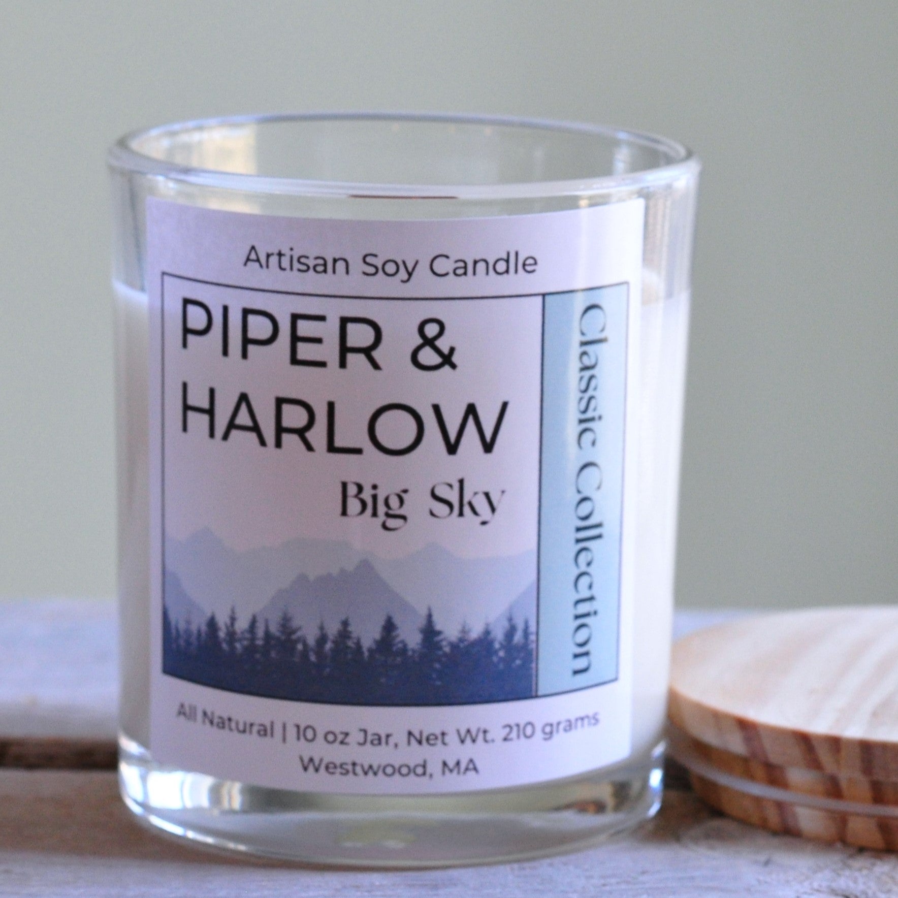 Big Sky scented soy candle in clear glass jar with wood lid and wood wick.