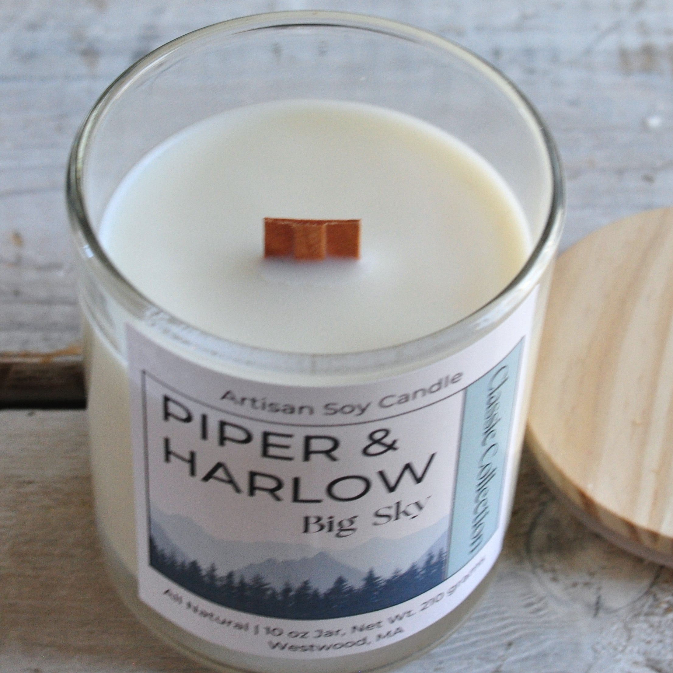 Big Sky scented soy candle in clear glass jar with wood lid and wood wick.