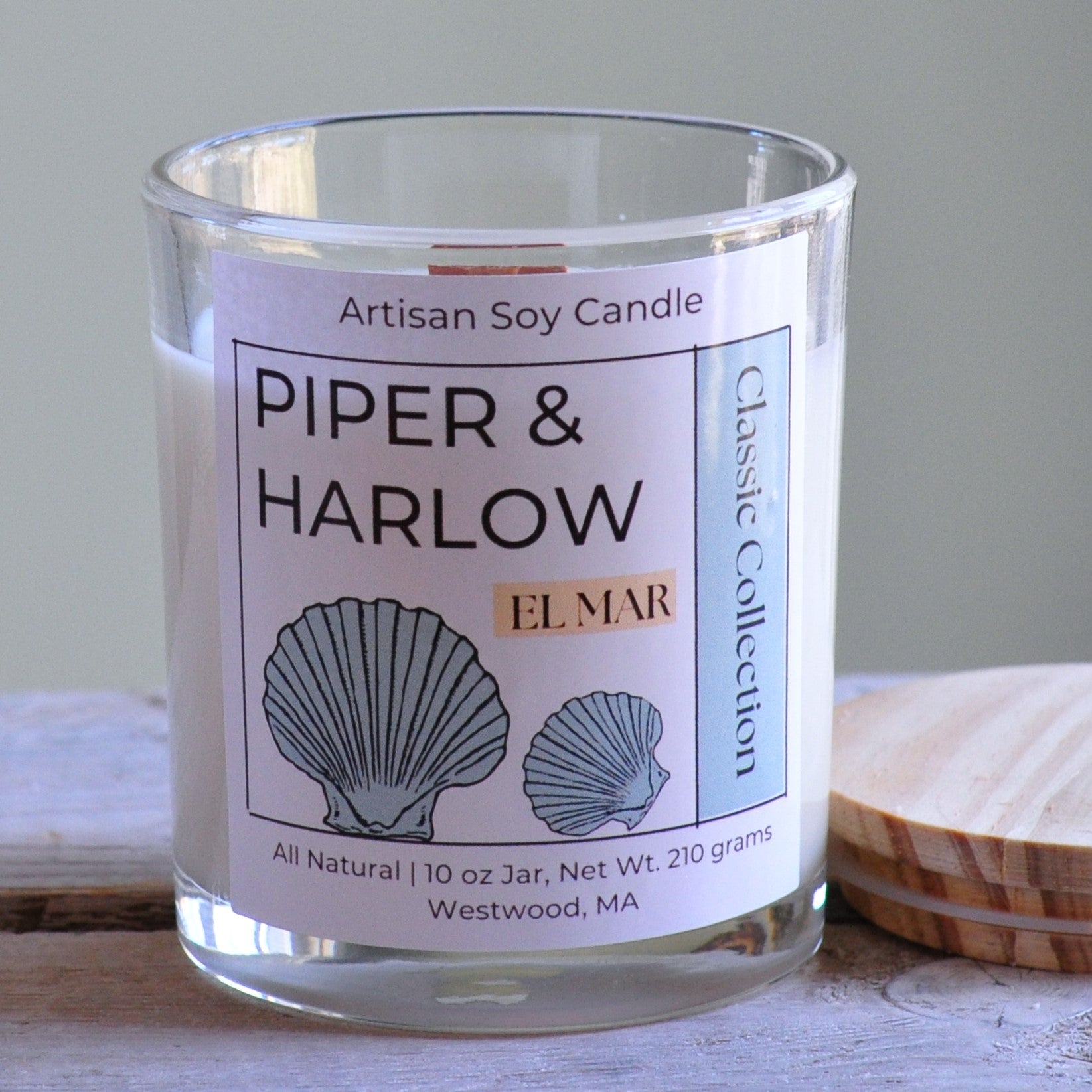 El Mar scented soy candle in clear glass jar with wood lid and wood wick.