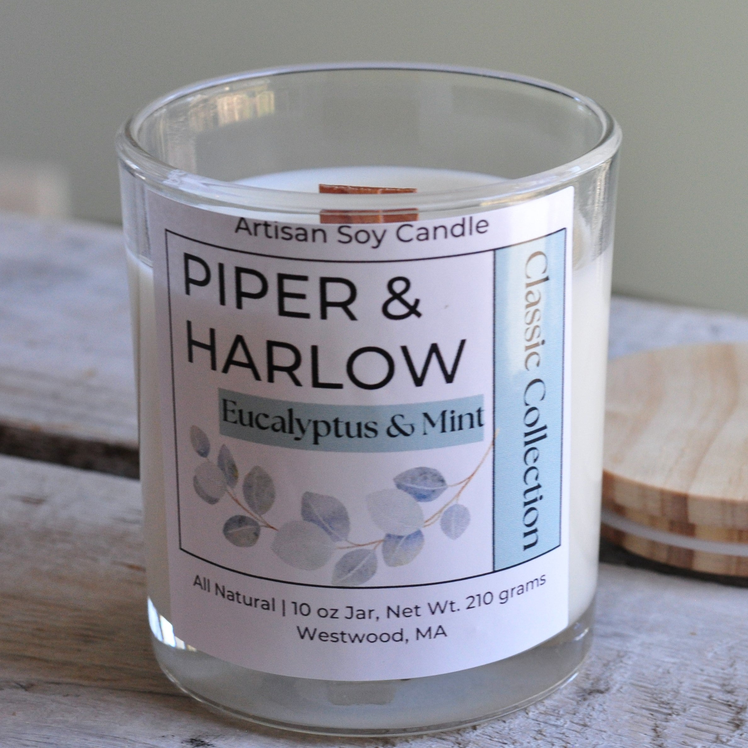 Eucalyptus and Mint scented soy candle in clear glass jar with wood lid and wood wick.