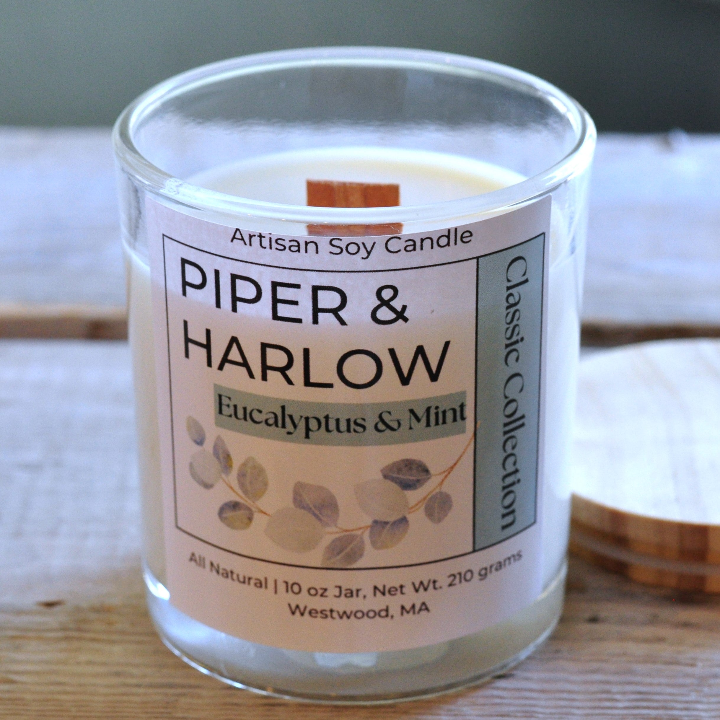 Eucalyptus and Mint scented soy candle in clear glass jar with wood lid and wood wick.