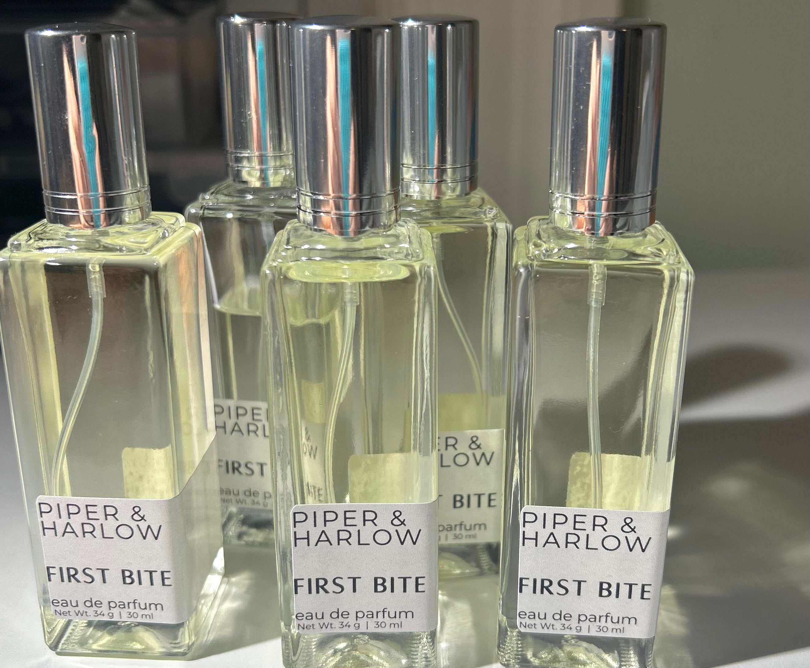 First Bite perfume bottles by Piper & Harlow on grey background.
